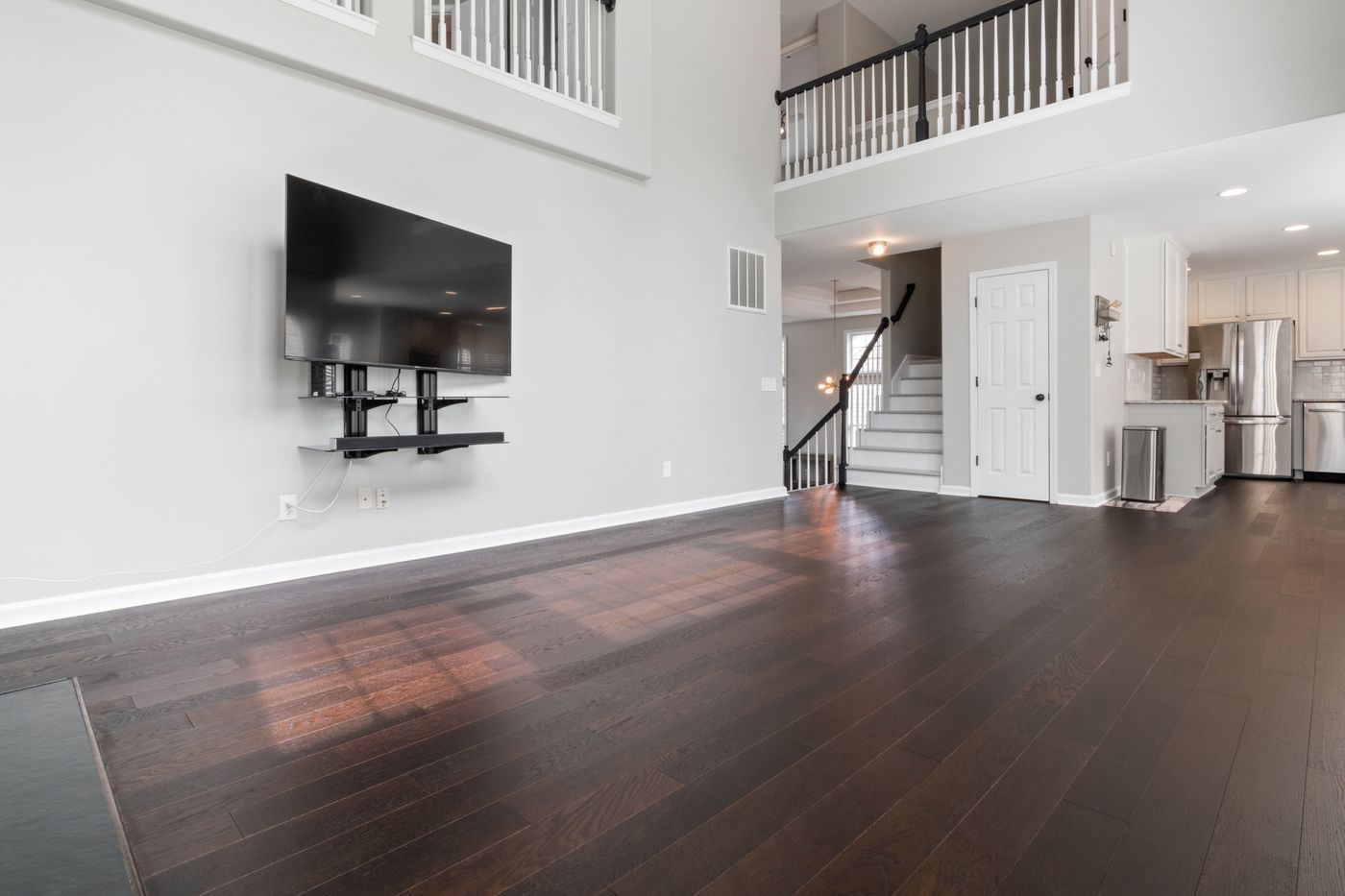 A large TV mounted on a wall bracket in a bright, open South Florida home